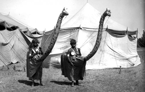 Native American (tribe unknown) men who are dressed as giraffes pose near a circus tent, Sunflower (Flower) Carnival, Colorado Springs, El Paso County, Colorado. 1898. [Horace Swartley Poley/Denver Public Library/Western History Collection)]