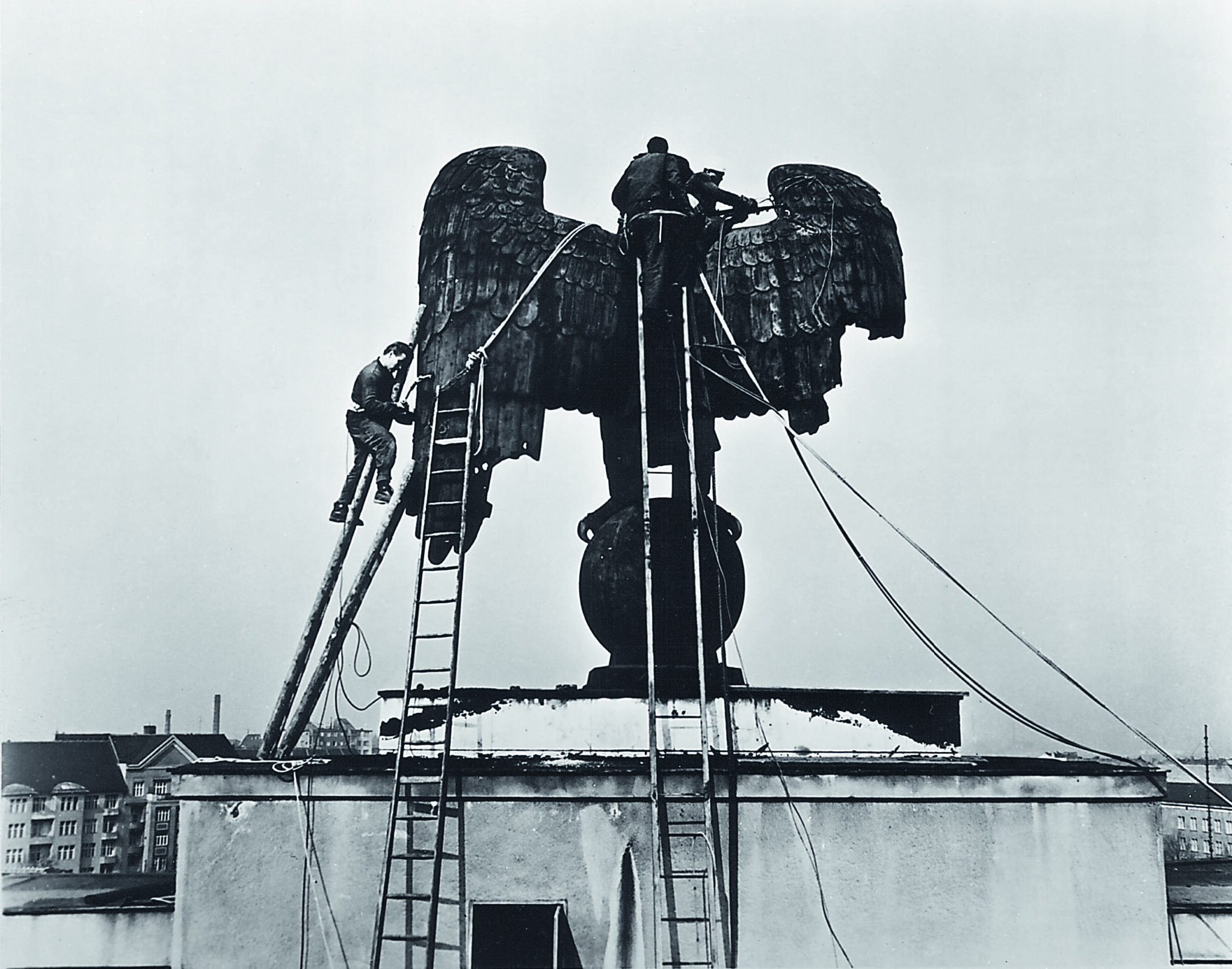 During Nazi Germany, Templehof Airport was crowned, sinde 1941, by an imperial eagle atop a globe. It was not until 1962 that American troops dismantled the sculpture and discarded everything except the eagle's head, which stands today at the airport on a plinth, where it was relocated in 1985.