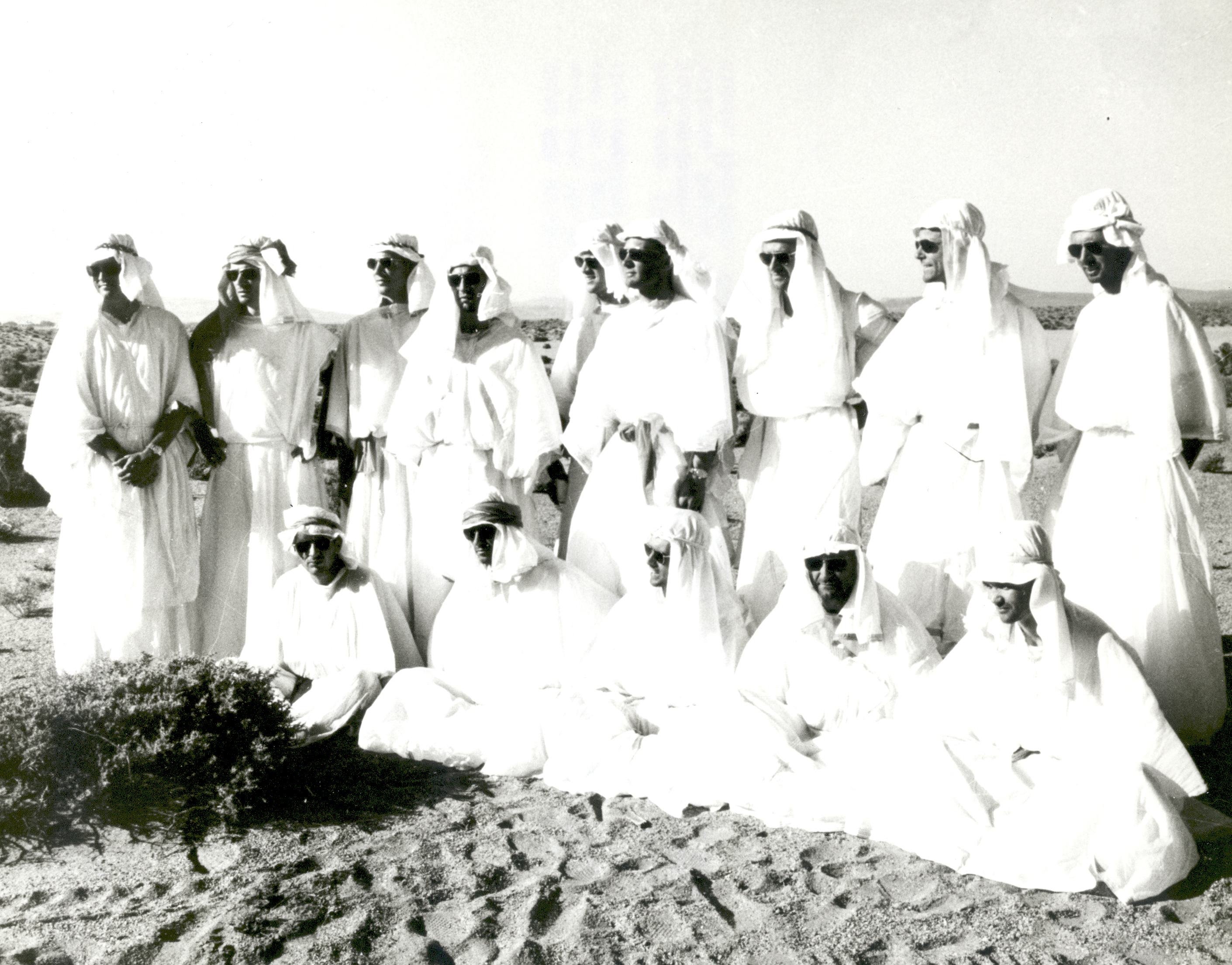 Fourteen NASA astronauts pose for group pictures at Stead Air Force Base in Nevada after a three-day stay in the Nevada desert where they completed a course in desert survival training. Front row: (left to right) William Anders, Walter Cunningham, Roger Chaffee, Richard Gordon, and Michael Collins. Second row: (left to right) Clifton Williams, Eugene Cernan, David Scott, Donn Eisele, Russell Schweickart, Edwin Aldrin, Alan Bean, Charles Bassett and Theodore Freeman, 1964.