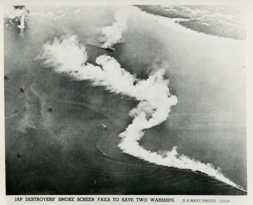 Japanese destroyer laying down a smoke screen near a coastline; explosions are visible in the background.. Leyte Island, Philippines. 1944.