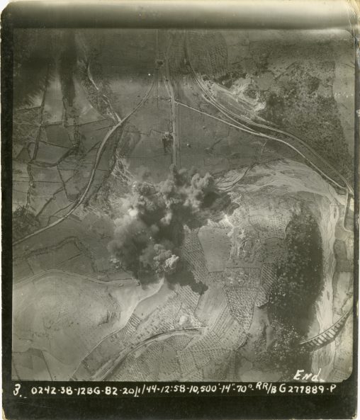 Aerial view showing circular pattern of rail lines and roads with bomb blasts in the center where a road bisects the terrain. Cineto Romano, Italy. 20 January 1944